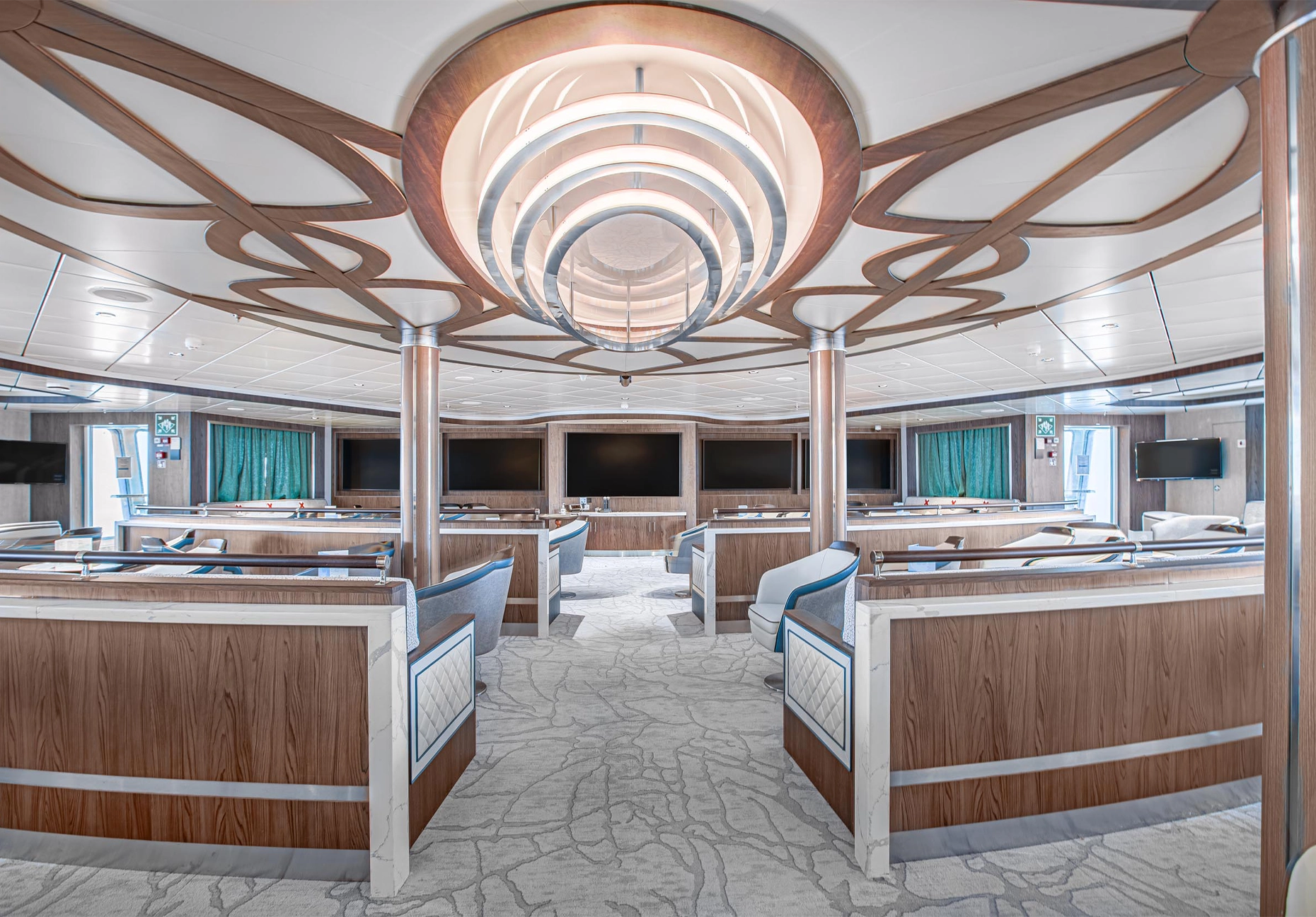 Tiered seating with swivel chairs facing a bank of screens beneath a curved ceiling feature
