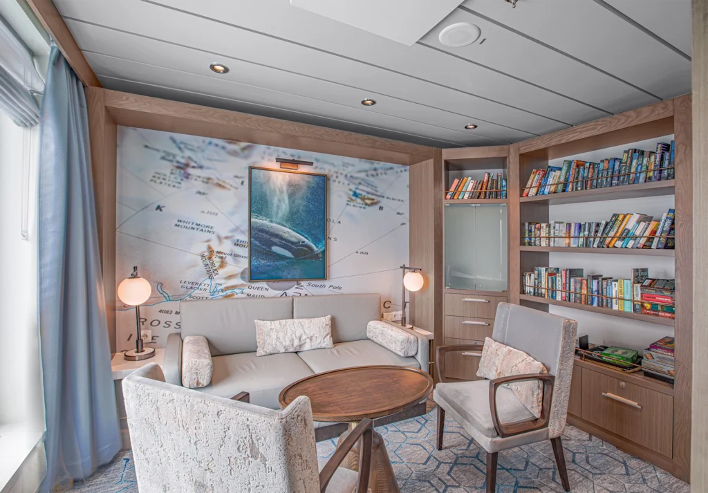 Bookshelves and seating beside a polar map wall with framed orca photograph