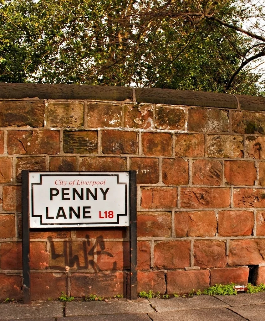 The City of Liverpool Penny Lane L18 street sign mounted on a red sandstone wall.